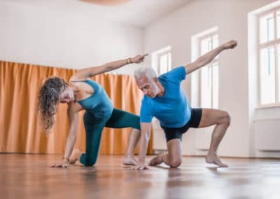 yoga teachers doing a variation of wild thing yoga asana in yoga studio