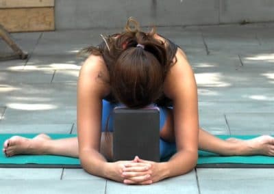 yoga teacher doing shoe lace yoga asana and stretching her back