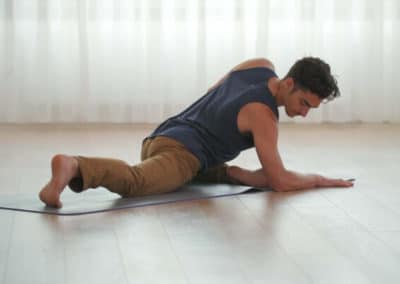 Matt Giordano stretching on yoga matt in inside yoga studio