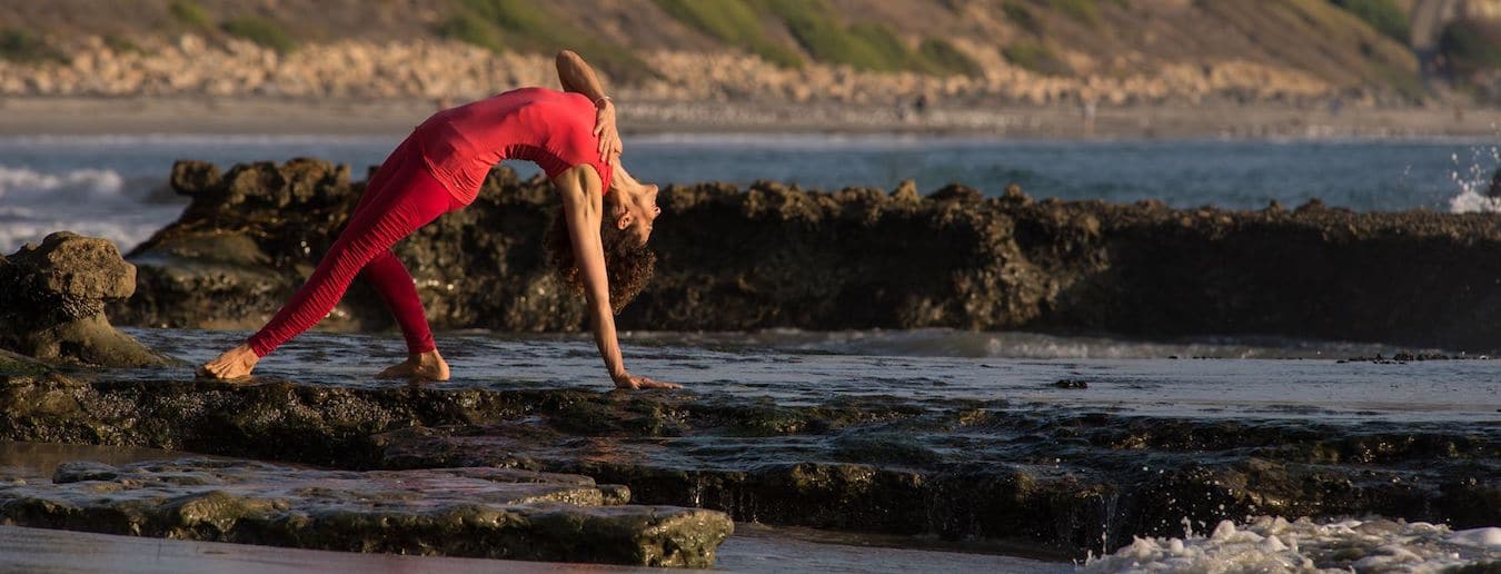 Desirée Rumbaugh in Yogapose Wild Thing am Meer